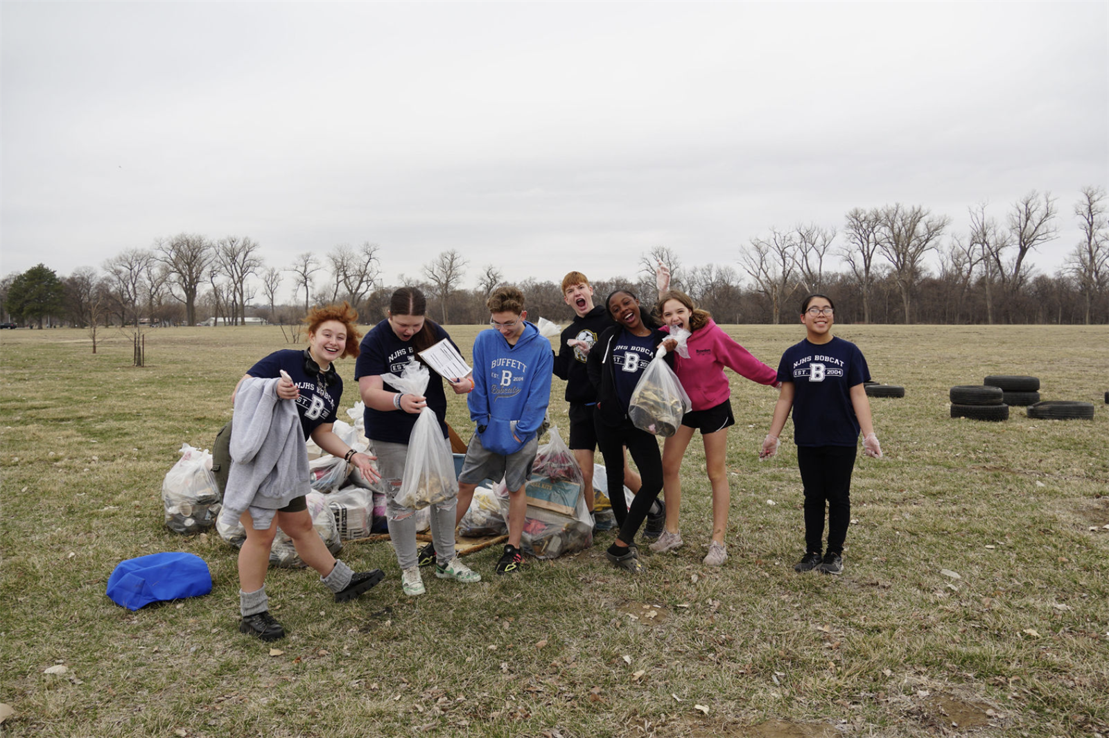  Students pose with bags of trash they picked up 